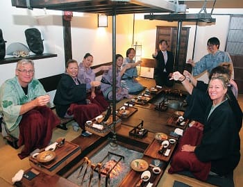 囲炉裏を囲んで和食を楽しむ豪州人旅行者たち