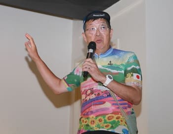 スクリーンを用いて北海道サイクリングの様子を紹介する小林茂雄氏（南富良野まちづくり協会）