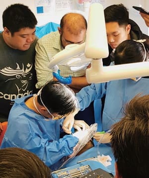 オステム社からの要請でインプラントの上級研修を指導するマシュー院長（左下）。多くの歯科医が院長の巧みな手技を観察中