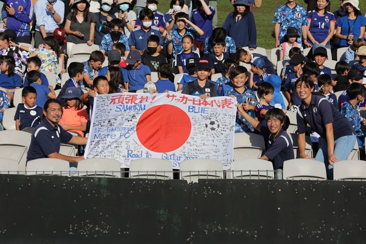 応援バナーを手にする元日本代表「MATE FC」代表･田代有三氏（バナー左手、撮影：馬場一哉）